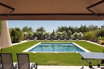 Finca Can Corem de Son Moix: Blick von der Terrasse im Parterre auf den Pool. Um den Pool gibt es Liegestühle und Sonnenschirme.